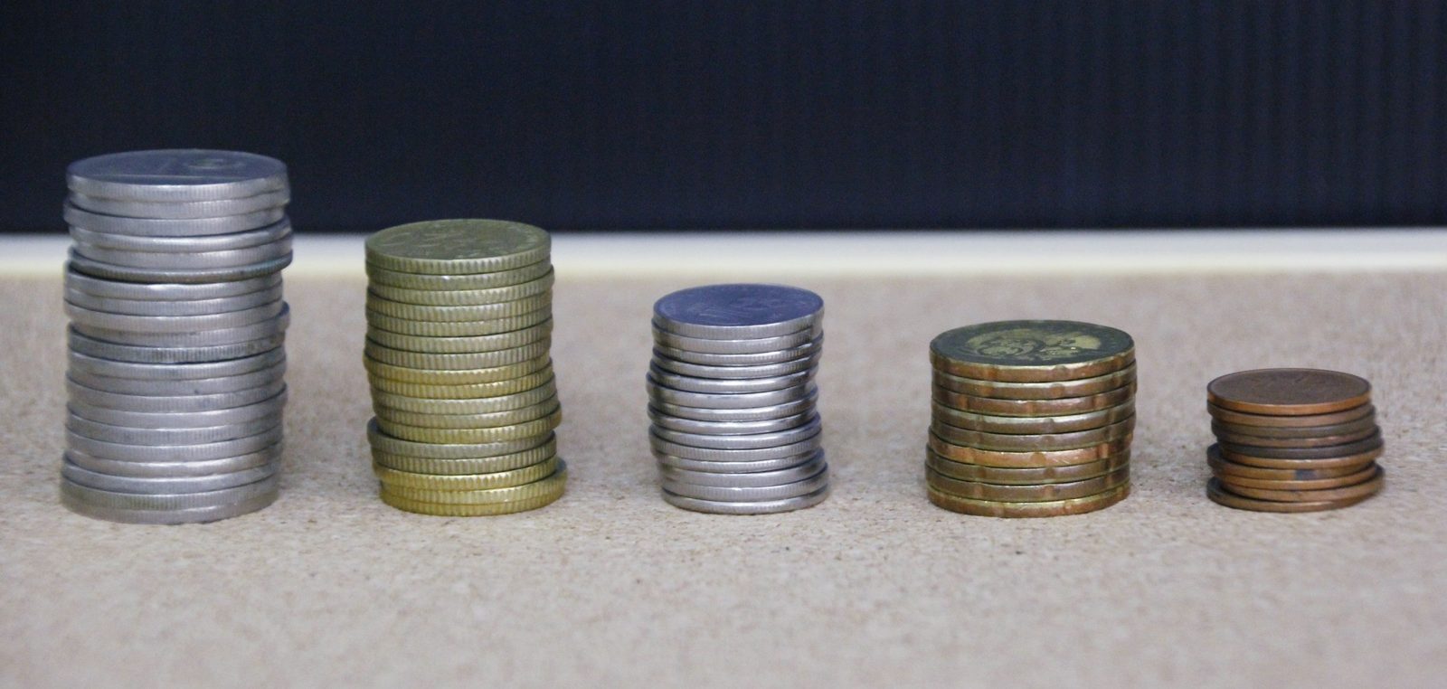 Stacks of silver and gold coins on a dark surface